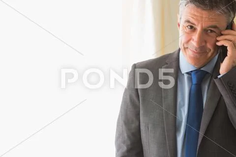 Amused man calling someone with his mobile phone Stock Photos