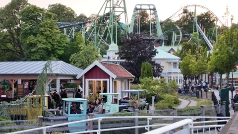Amusement Park View with Roller Coasters and Visitors Among the Buildings Video stock 347681397