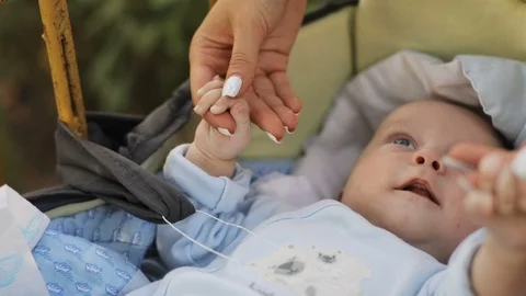 Amusing boy holding hands of mother. Adorable baby boy looking at young woman Stock Footage 117272114