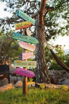 Amusing direction signpost with distances to different places under pine tree Stock Photos
