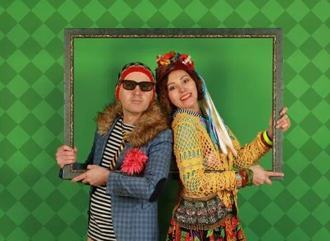 Amusing freaky couple posing in the studio holding a picture frame in their h Fotos de archivo