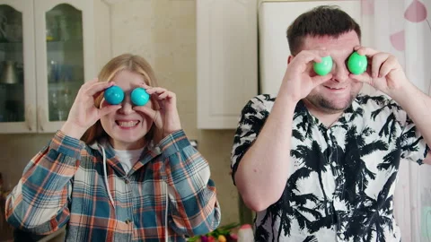 Amusing moment with partners designing humorous faces on decorated eggs Video stock 330497995
