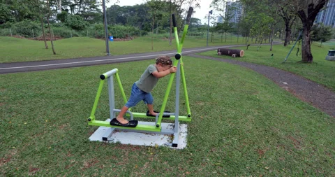 Amusing toddler start exercising on outdoor ski simulator machine Vídeos de archivo 345804098