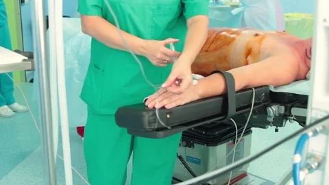 The anaesthesiologist inserts the pripert through the catheter on the patient's  Vidéo 70003269