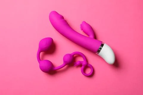 Sex toy. Black butt plag and donut on a pink background. Useful