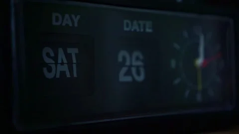 Analog clock face with flipping calendar display, dark setting, time passage Stock Footage 345871098