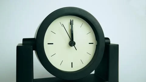 Analog clock without numbers shows five seconds to midnight or noon Stock Photos