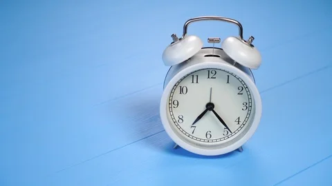 Analog gray alarm clock on a blue creative wooden background with texture. Mo 動画素材 125885787