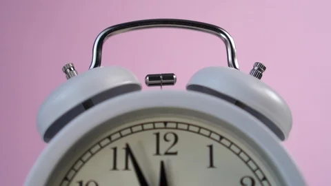 Analog gray alarm clock rings on a pink creative fashion background 動画素材 125885840