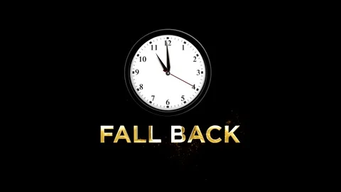 Analog wall clock showing the time with golden glowing fall back text effect Stock Footage 346541972