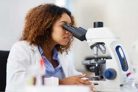 Analysing microscopic data. Cropped shot of a young female scientist looking  Stock Photos