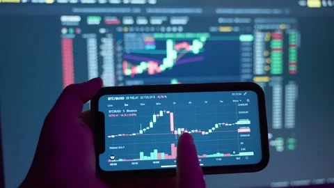 Analysis of the cryptocurrency chart on the phone screen. Stock Footage 231415656
