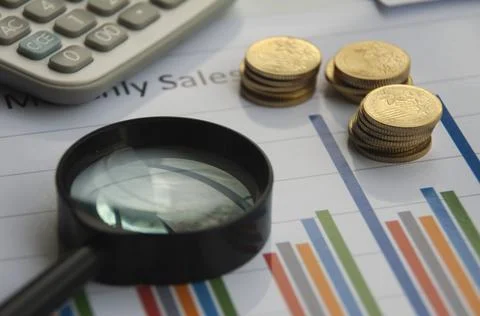 Analysis of data, chart and graphs with calculator, magnifying glass and gold Stock Photos