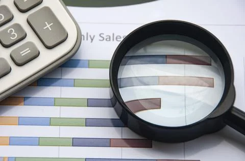 Analysis of data, chart and graphs with calculator and magnifying glass. Foto stock