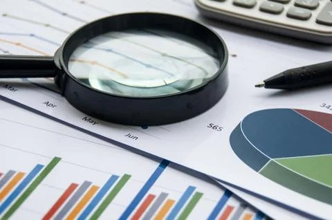 Analysis of data, chart and graphs with calculator and magnifying glass. Bu.. Stock Photos