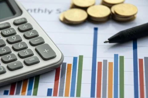 Analysis of data, chart and graphs with calculator, pen and gold coins back.. Stock Photos