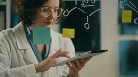 Analysis, Middle-aged woman keeps looking into the screen of the tablet chec Stock Footage 243847702