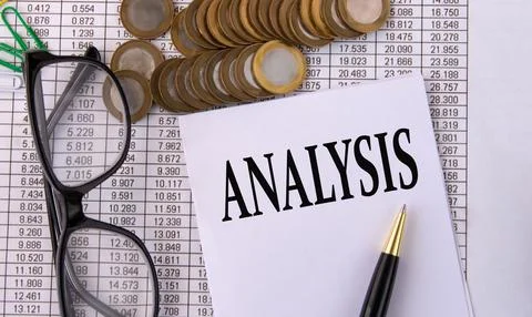 ANALYSIS - word on a white sheet of paper on the background of pennies and gl Stock Photos