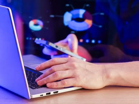 Analyst multitasking with devices against pie chart data display Foto stock