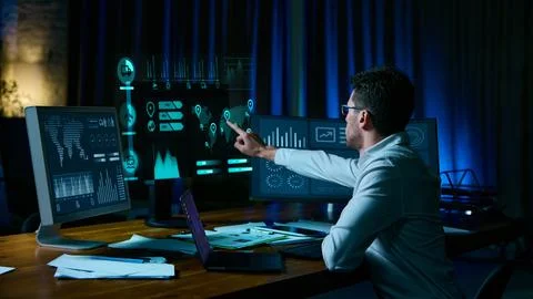 Analyst pointing at digital logistics data screens in modern workspace. Collage Foto stock