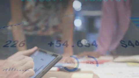 Analyst tapping tablet and updating animated chart overlays while team sketching Stock Footage 334768504