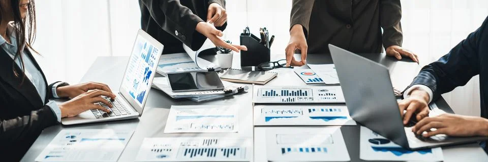 Analyst team analyzing business data paper on office table. Prodigy Stock Photos
