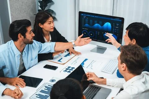 Analyst team utilizing BI Fintech to analyze financial data at table. Prudent Stock Photos