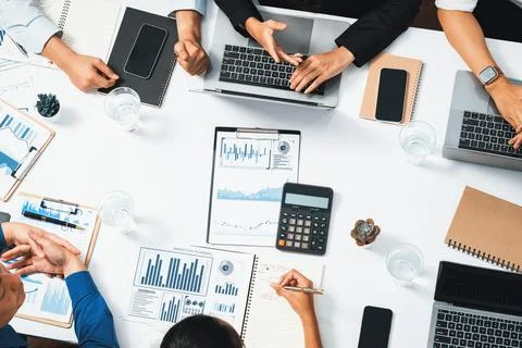 Analyst team utilizing BI Fintech to analyze financial data at table. Prudent Stock Photos