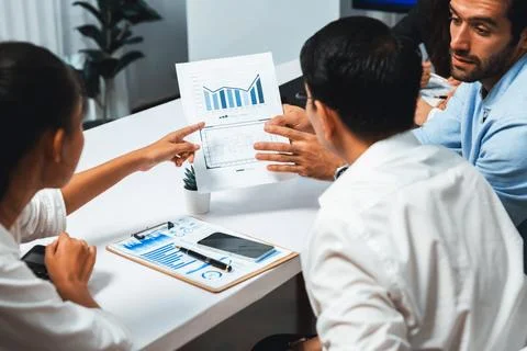 Analyst team utilizing BI Fintech to analyze financial data at table. Prudent Stock Photos