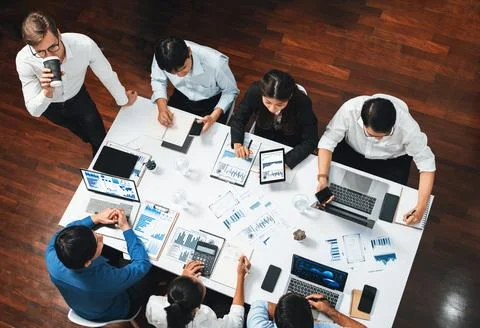 Analyst team utilizing BI Fintech to analyze financial data at table. Prudent Stock Photos