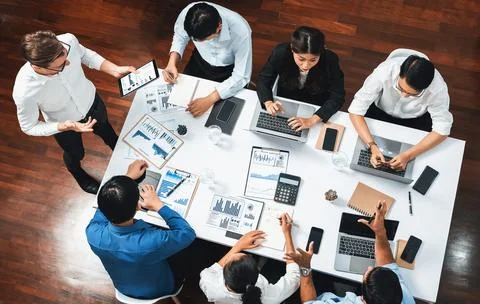 Analyst team utilizing BI Fintech to analyze financial data at table. Prudent Stock Photos