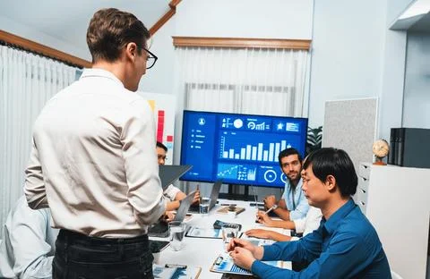 Analyst team utilizing BI Fintech to analyze financial data at table. Prudent Stock Photos