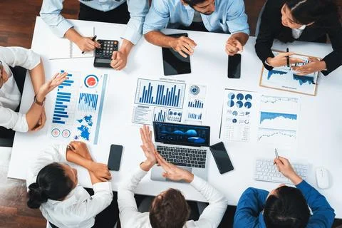 Analyst team utilizing BI Fintech to analyze financial data at table. Prudent Stock Photos
