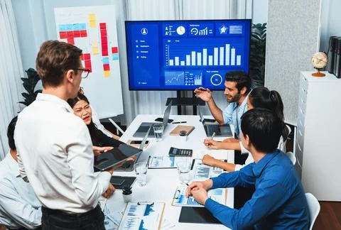 Analyst team utilizing BI Fintech to analyze financial data at table. Prudent Stock Photos