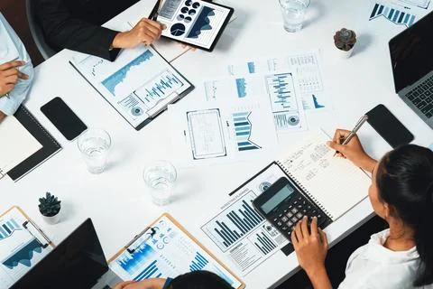 Analyst team utilizing BI Fintech to analyze financial data at table. Prudent Stock Photos