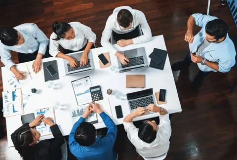 Analyst team utilizing BI Fintech to analyze financial data at table. Prudent Stock Photos
