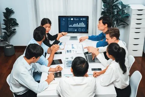 Analyst team utilizing BI Fintech to analyze financial data at table. Prudent Stock Photos