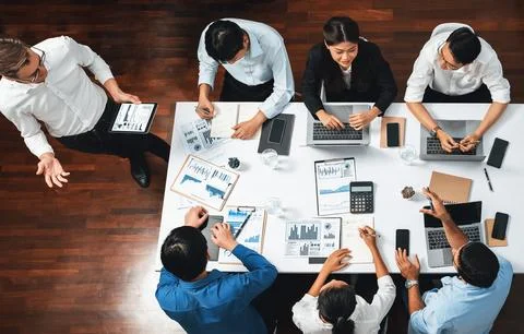 Analyst team utilizing BI Fintech to analyze financial data at table. Prudent Stock Photos