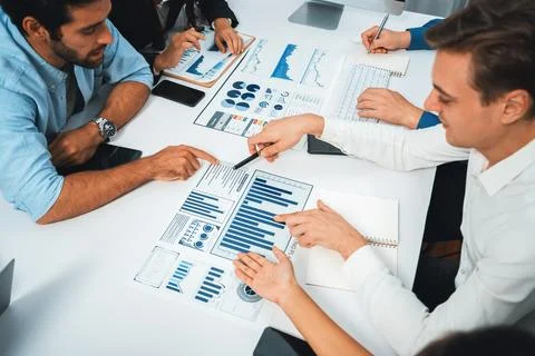 Analyst team utilizing BI Fintech to analyze financial data at table. Prudent Stock Photos