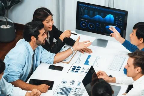 Analyst team utilizing BI Fintech to analyze financial data at table. Prudent Stock Photos