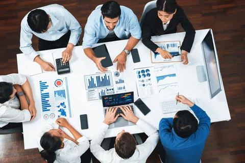 Analyst team utilizing BI Fintech to analyze financial data at table. Prudent Stock Photos