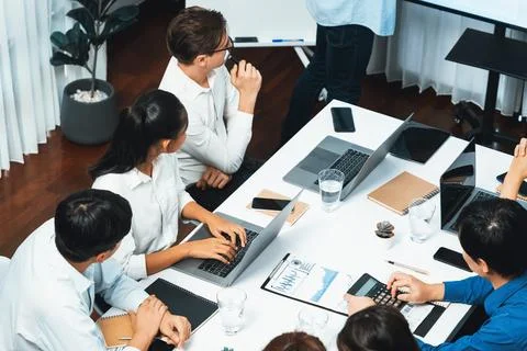 Analyst team utilizing BI Fintech to analyze financial data at table. Prudent Stock Photos