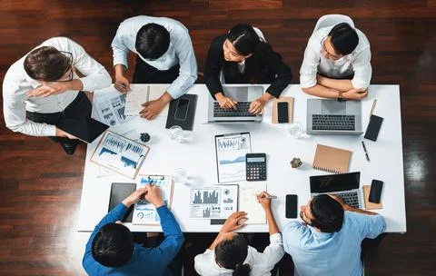 Analyst team utilizing BI Fintech to analyze financial data at table. Prudent Stock Photos