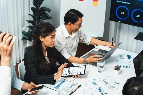Analyst team utilizing BI Fintech to analyze financial data at table. Prudent Stock Photos