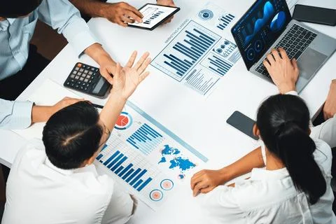 Analyst team utilizing BI Fintech to analyze financial data at table. Prudent Stock Photos