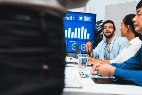 Analyst team utilizing BI Fintech to analyze financial data at table. Prudent Stock Photos