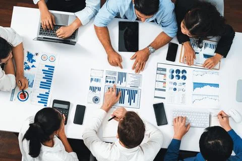 Analyst team utilizing BI Fintech to analyze financial data at table. Prudent Stock Photos