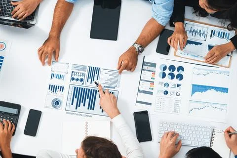 Analyst team utilizing BI Fintech to analyze financial data at table. Prudent Stock Photos