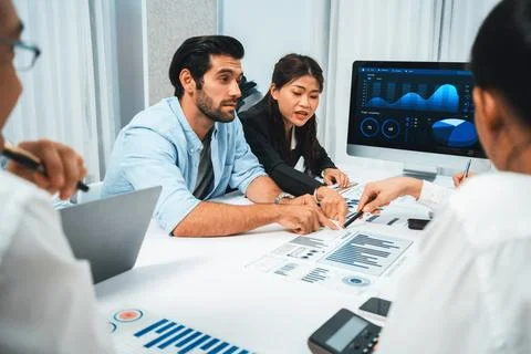 Analyst team utilizing BI Fintech to analyze financial data at table. Prudent Stock Photos