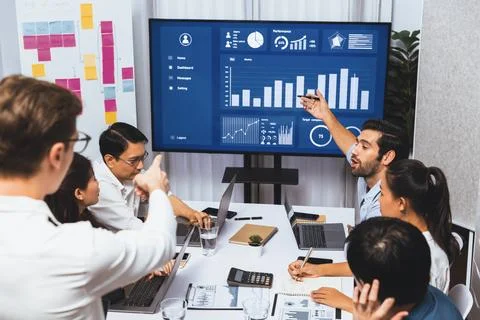 Analyst team utilizing BI Fintech to analyze financial data at table. Prudent Stock Photos